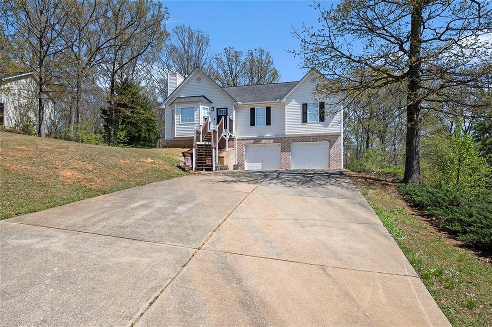 View of front facade with an attached garage, a ch