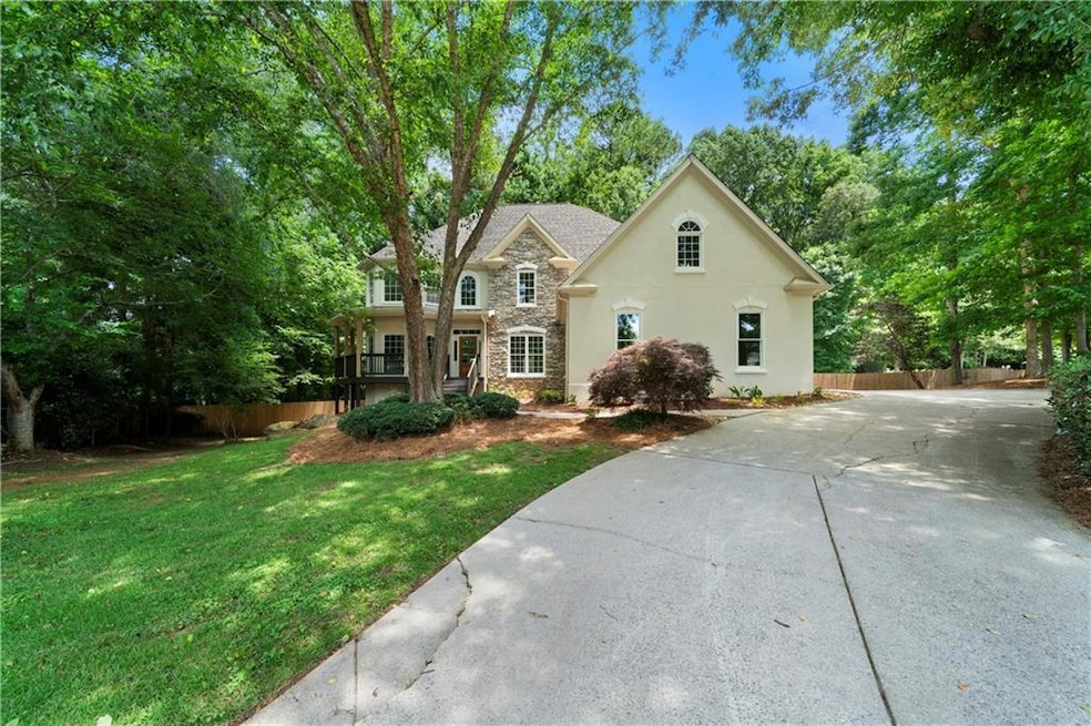 View of front of home featuring stone siding, stucco siding, driveway, and a porch