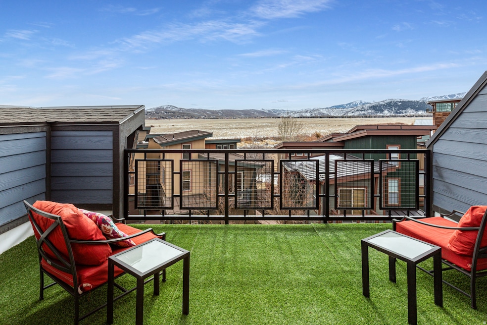 View of grassy yard with a mountain view and a balcony