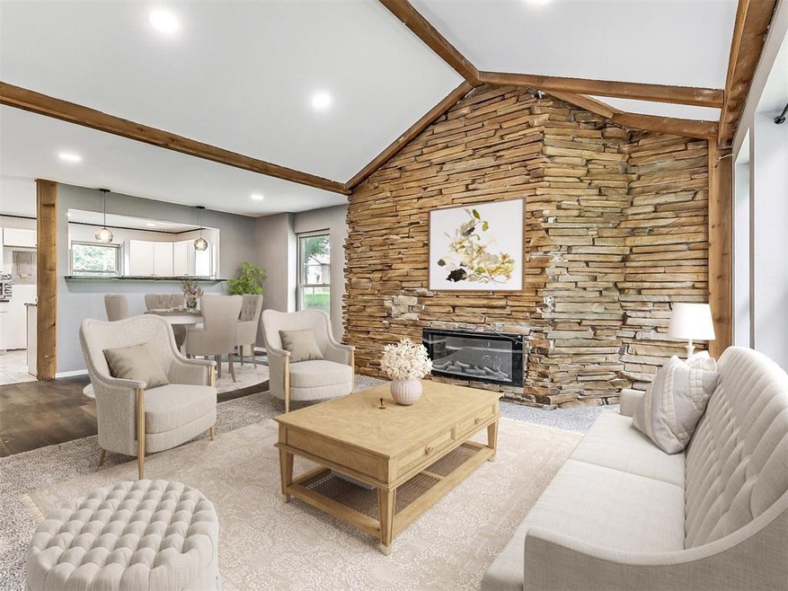 Living room with vaulted ceiling with beams, a sto