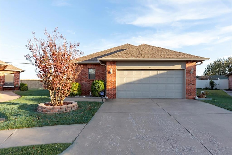 Ranch-style house featuring a shingled roof, concrete driveway, brick siding, and a garage