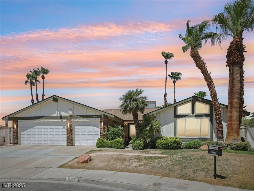 Mid-century inspired home with a garage, concrete driveway, and brick siding