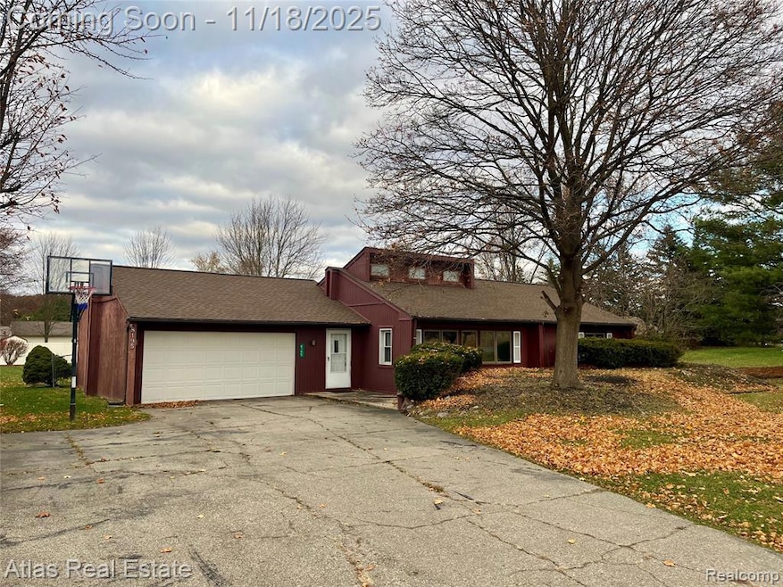 View of front of home with roof with shingles, driveway, and a garage