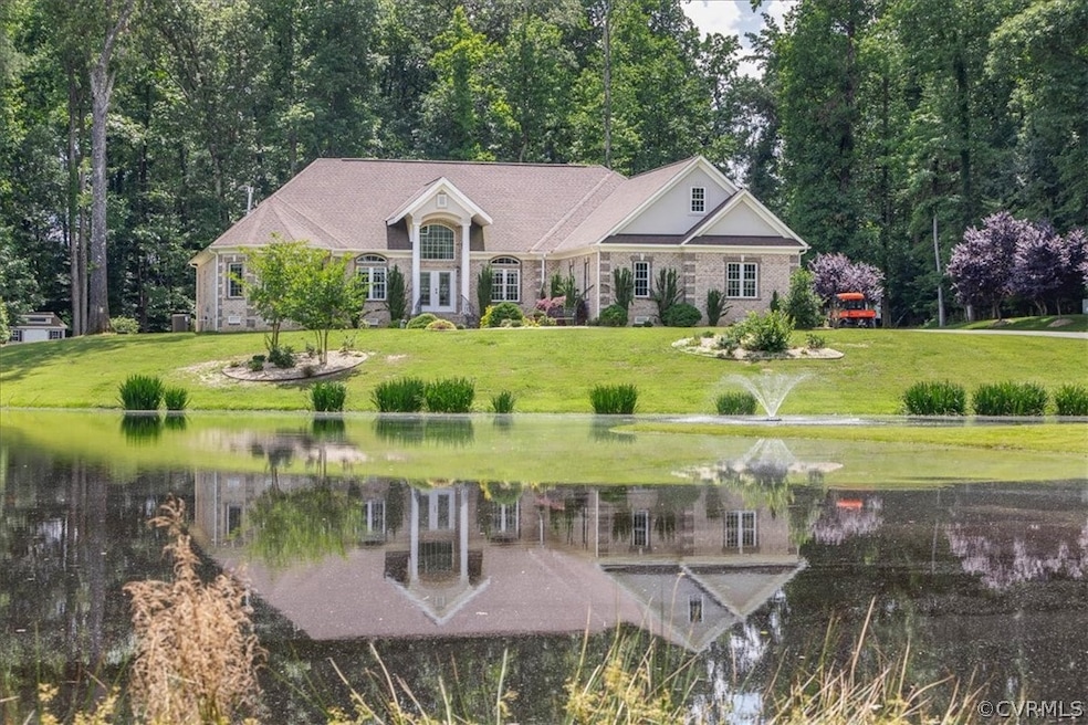 Front of house with a water view and a lawn