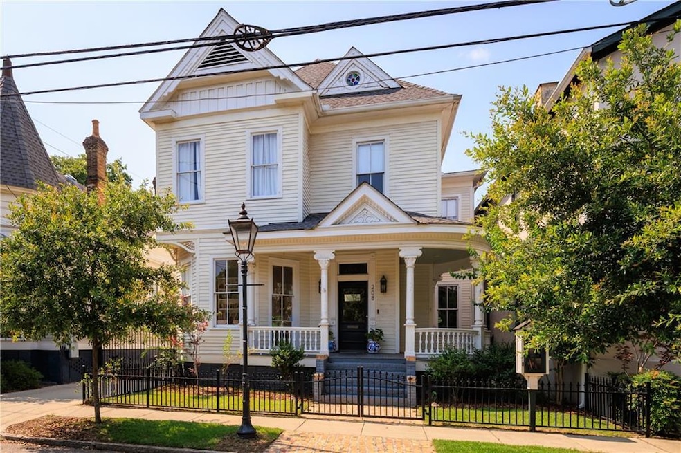 View of front of property featuring covered porch, a fenced front yard