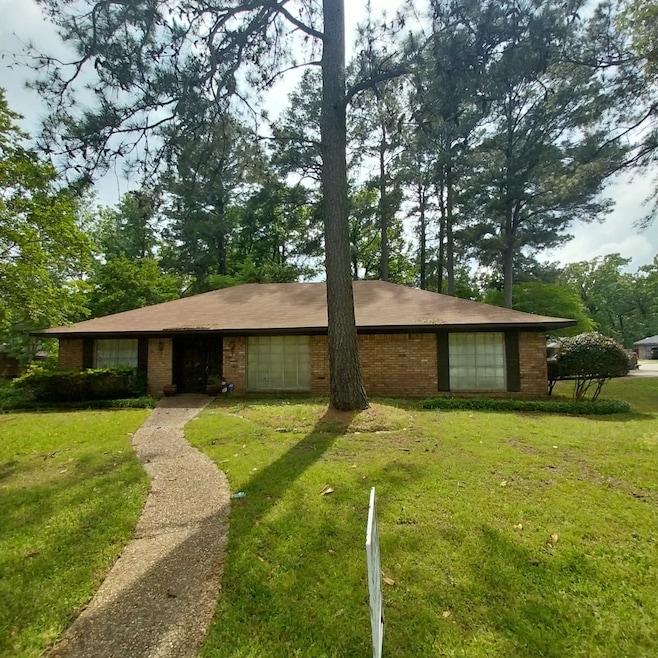 Ranch-style home with a front lawn and brick siding