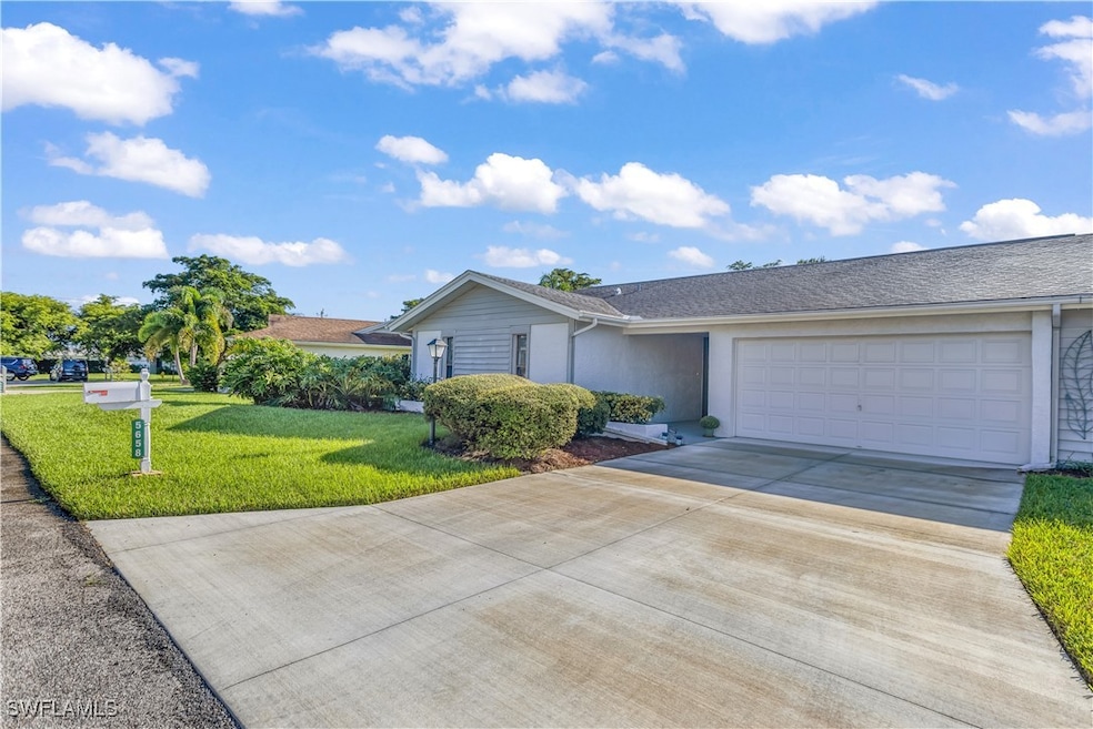 Single story condo home with a front lawn and a ga
