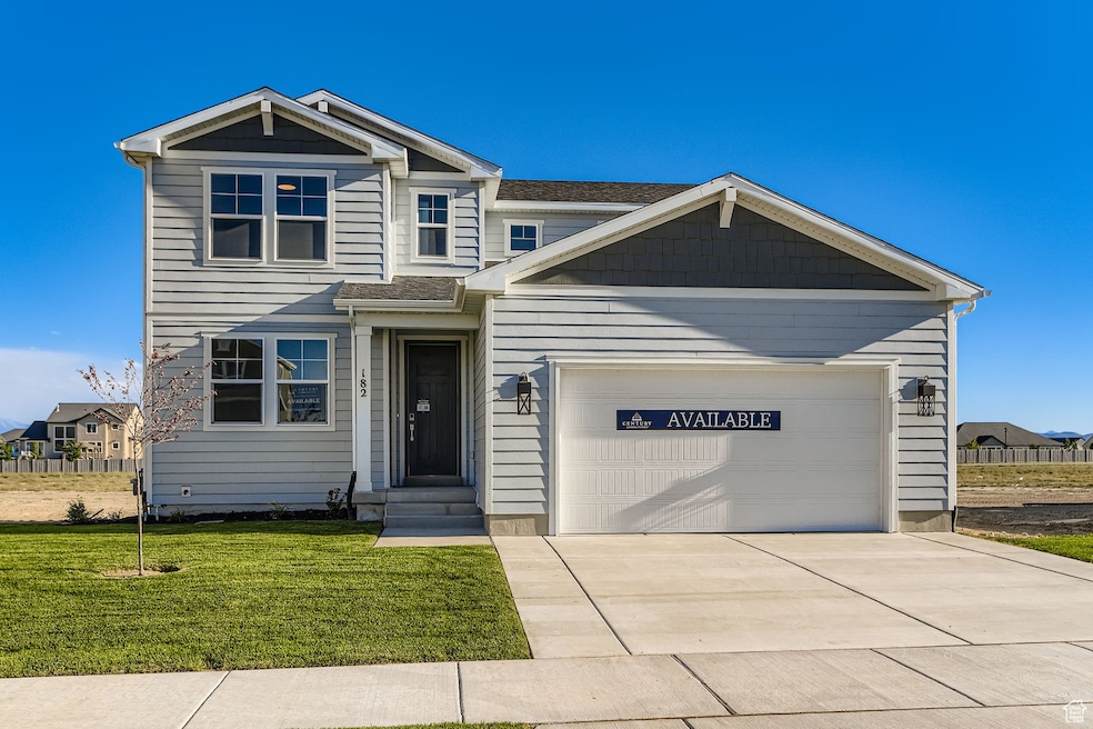 View of front of property featuring driveway, an attached garage, and a front yard