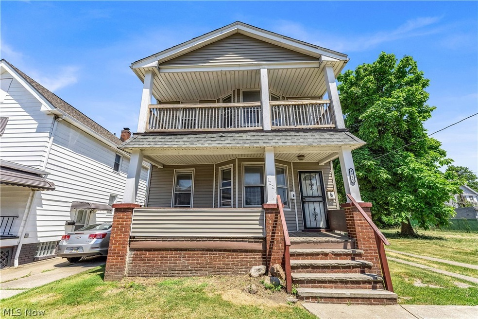 View of front facade with a front yard and a balcony