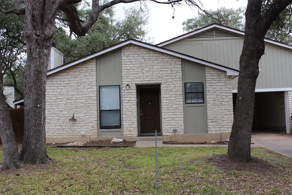 View of front of home with stone siding, driveway