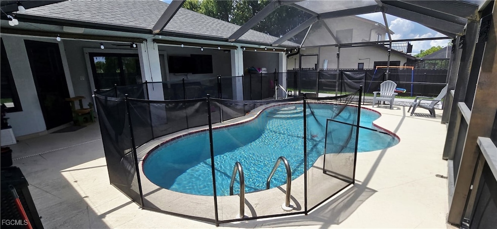 View of pool with a patio area and glass enclosure