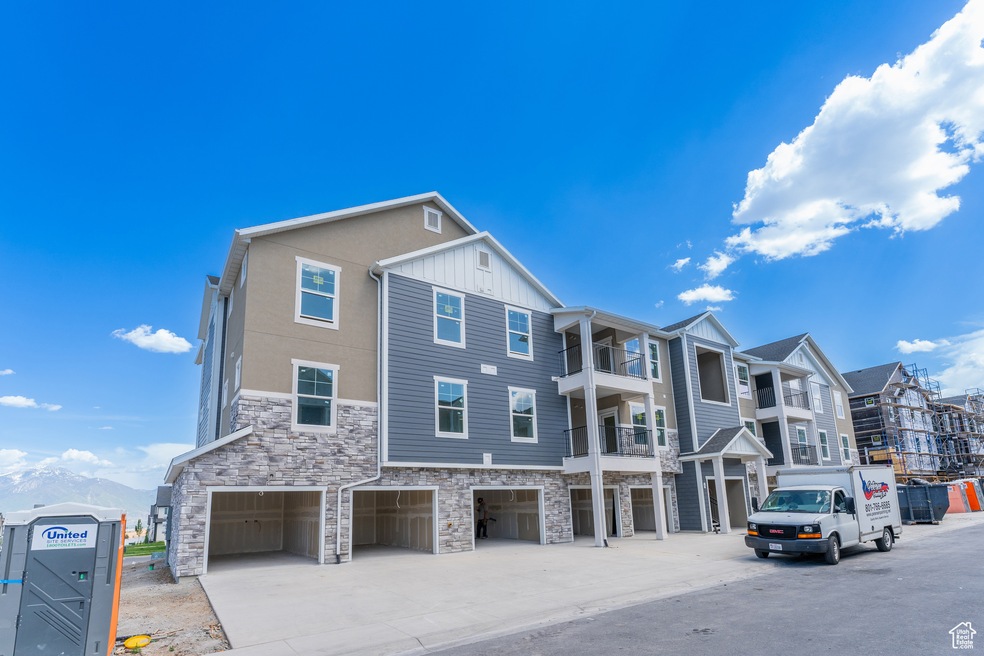 View of building exterior with a garage and concrete driveway