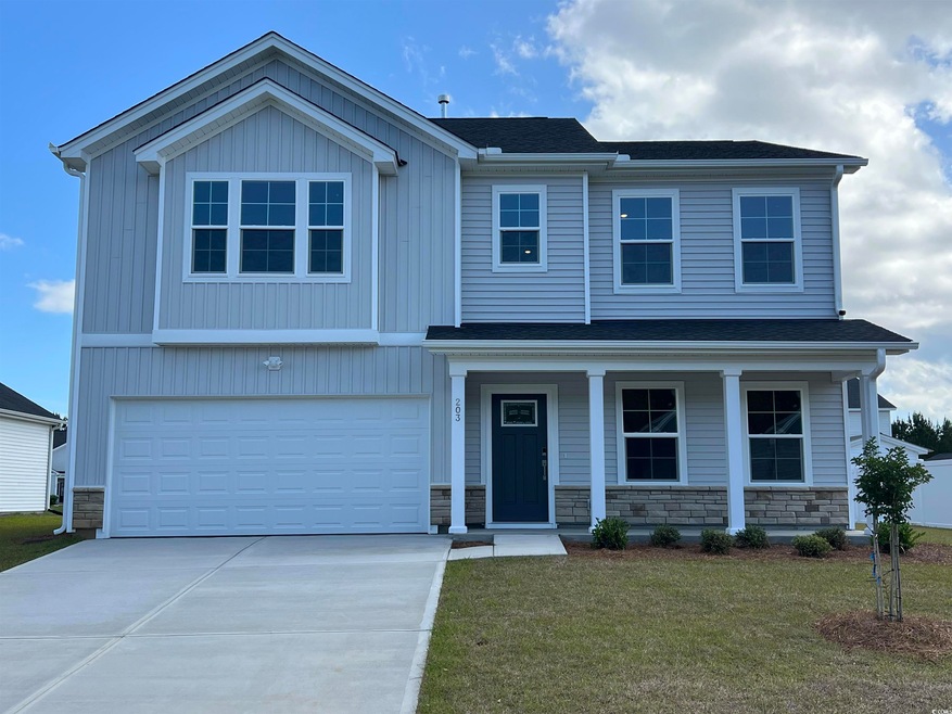 View of front facade with driveway, a garage, ston