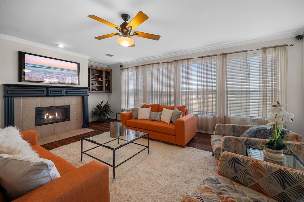 Living room with ceiling fan, a fireplace, wood-ty