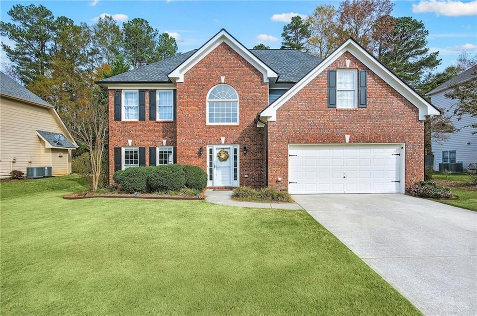 View of front of property with a front yard, a gar