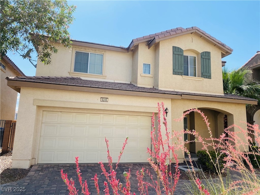 View of front of home with a tile roof, a garage,