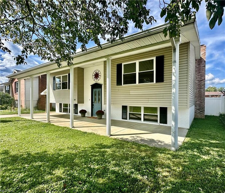 Bi-level home with a patio area and a front lawn