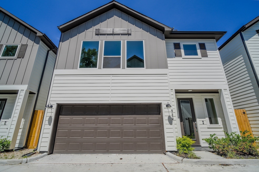 Contemporary design with bold roof angles and wood accents. Spacious garage and bright upper-level windows complete the look.