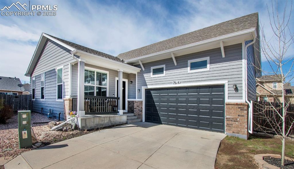 View of front of home with fence, roof with shingles, and a garage