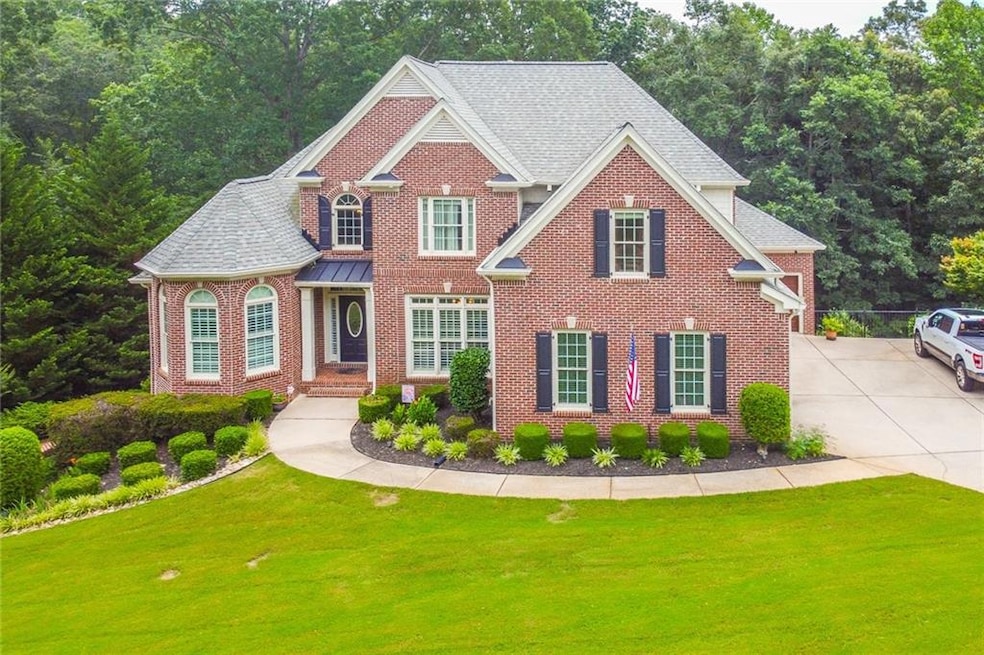 View of front facade with brick siding, a front yard, and driveway