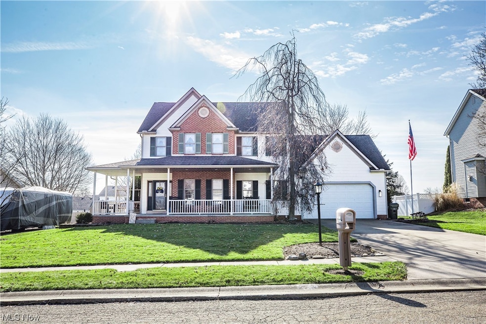 View of front facade with a front lawn, a garage, and covered porch