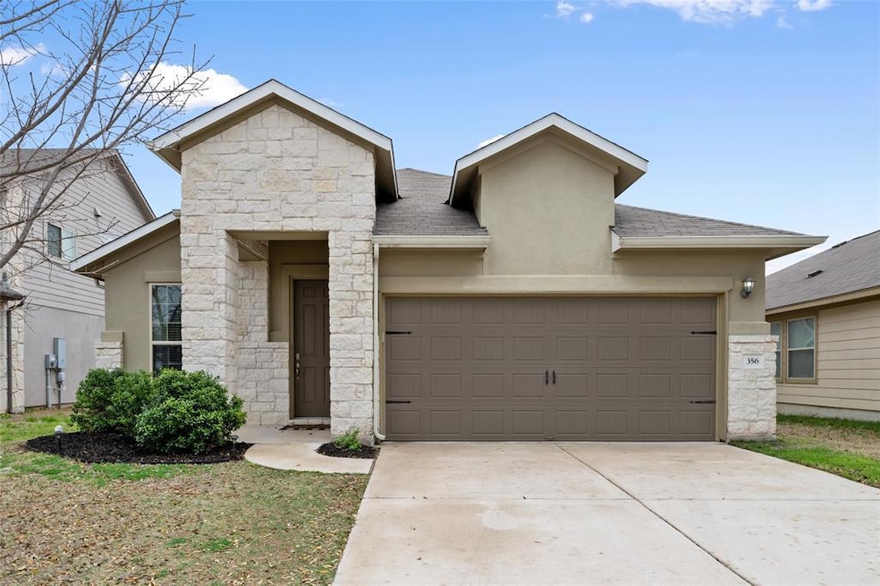 View of front of house with stone siding, stucco siding, concrete driveway, and an attached garage