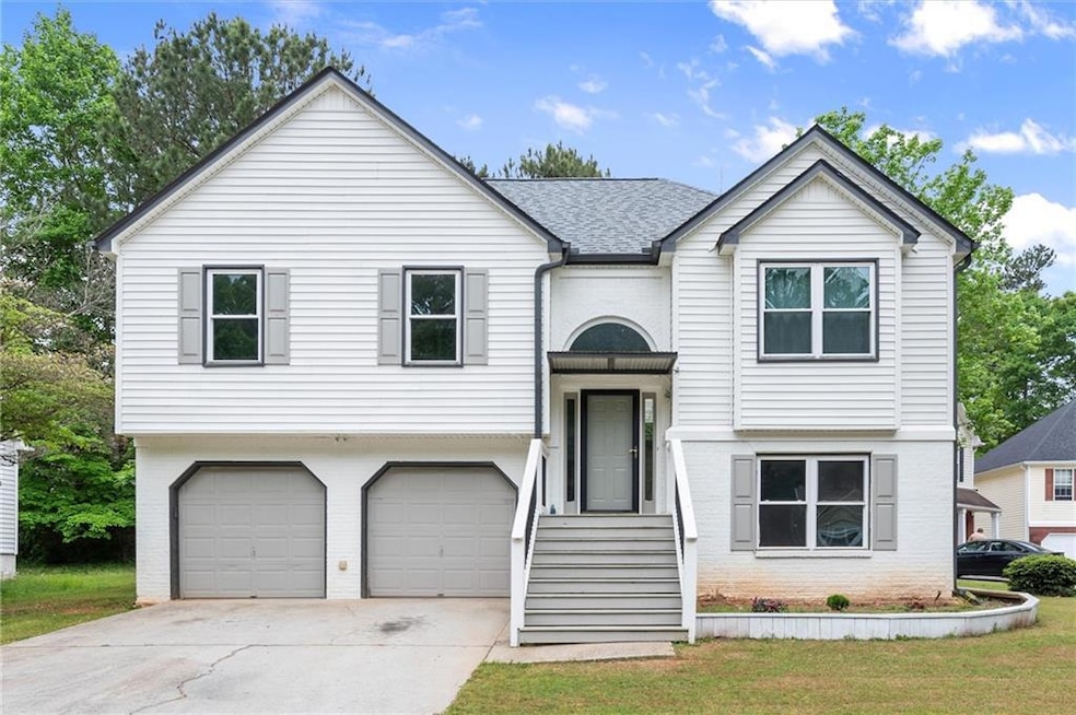 Bi-level home featuring a shingled roof, driveway,