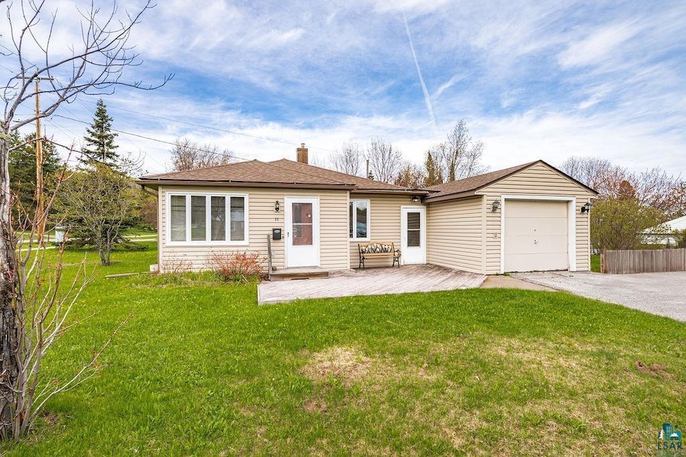 Front of house featuring a garage, driveway, a chimney, and a shingled roof