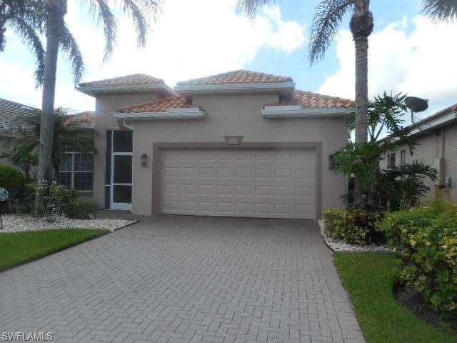 Mediterranean / spanish-style house featuring an attached garage, stucco siding, decorative driveway, and a tile roof