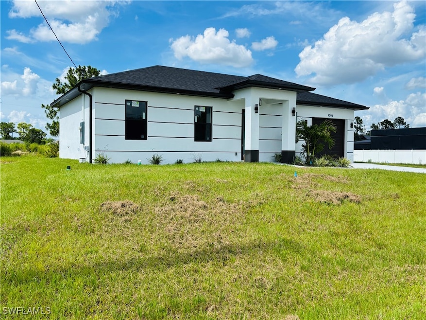 View of side of home featuring a yard and a garage