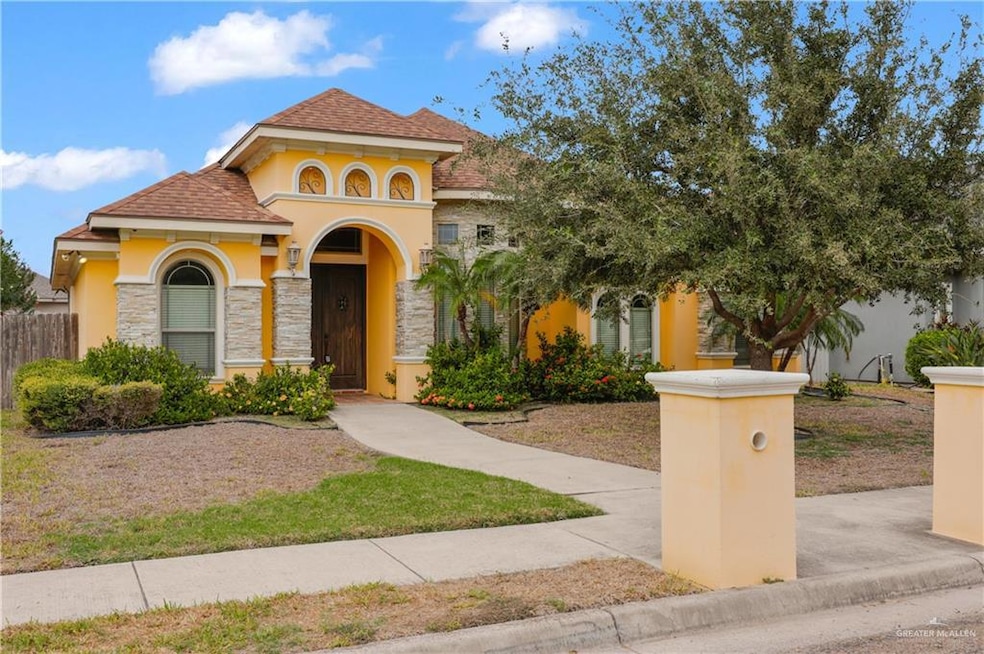 Mediterranean / spanish-style home with stucco siding, roof with shingles, and stone siding