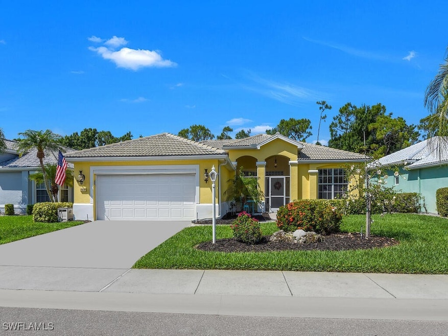 Ranch-style home with a garage, a tile roof, stucc