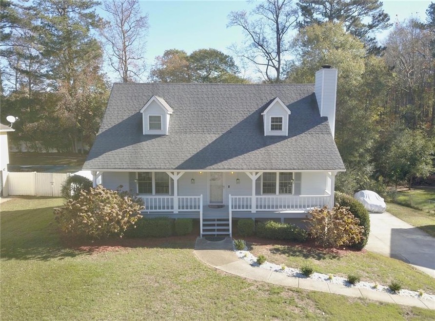 Cape cod house featuring covered porch and a front