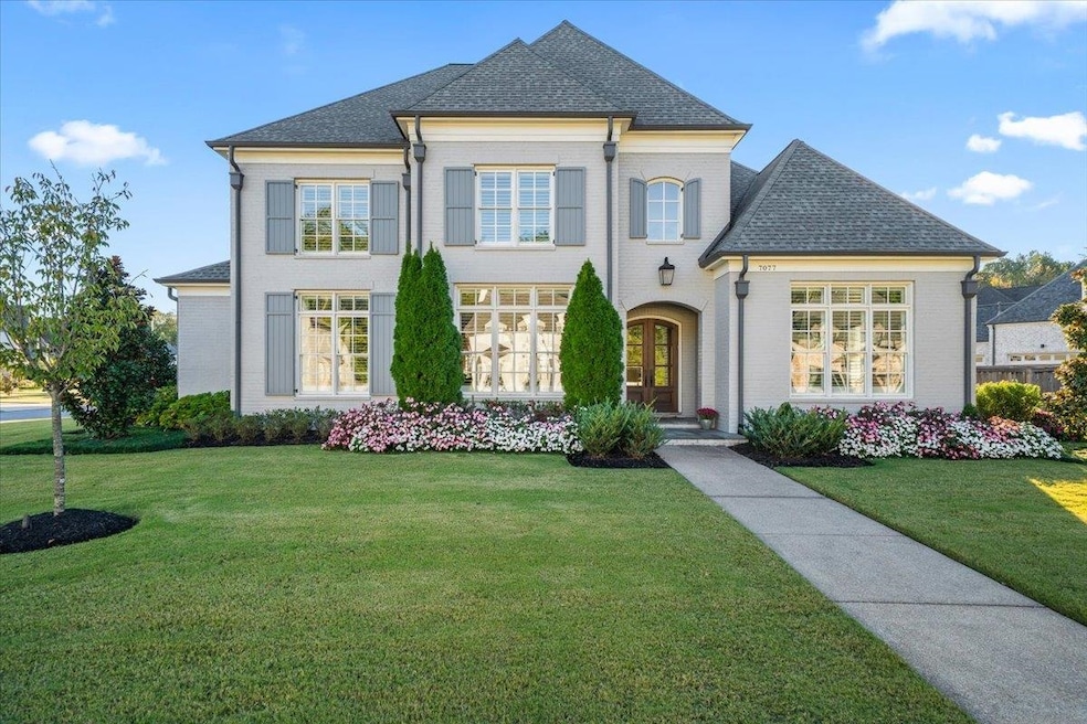 French provincial home featuring a front lawn, brick siding, a shingled roof, and french doors