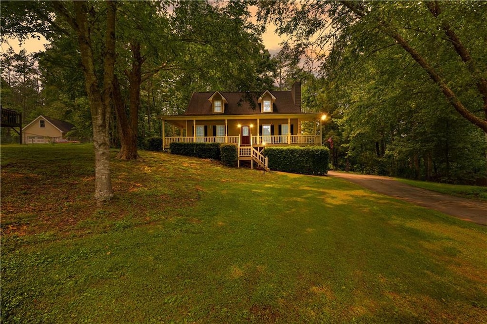 View of front facade with covered porch, a chimney, and a yard