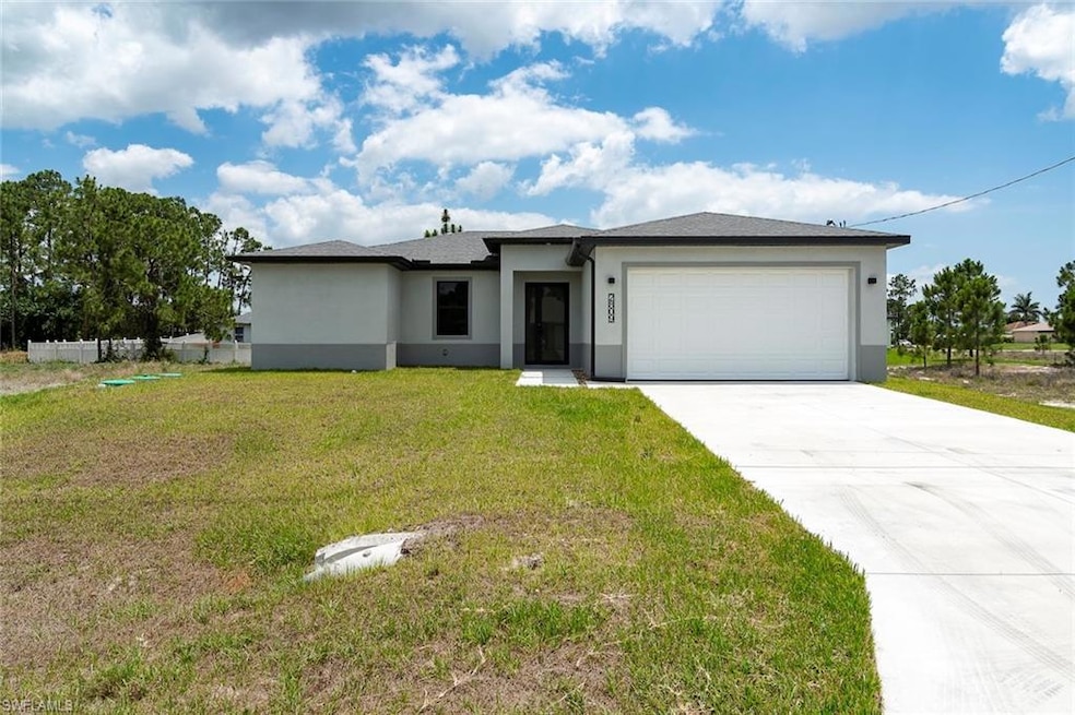 Prairie-style home with a garage, stucco siding, and driveway