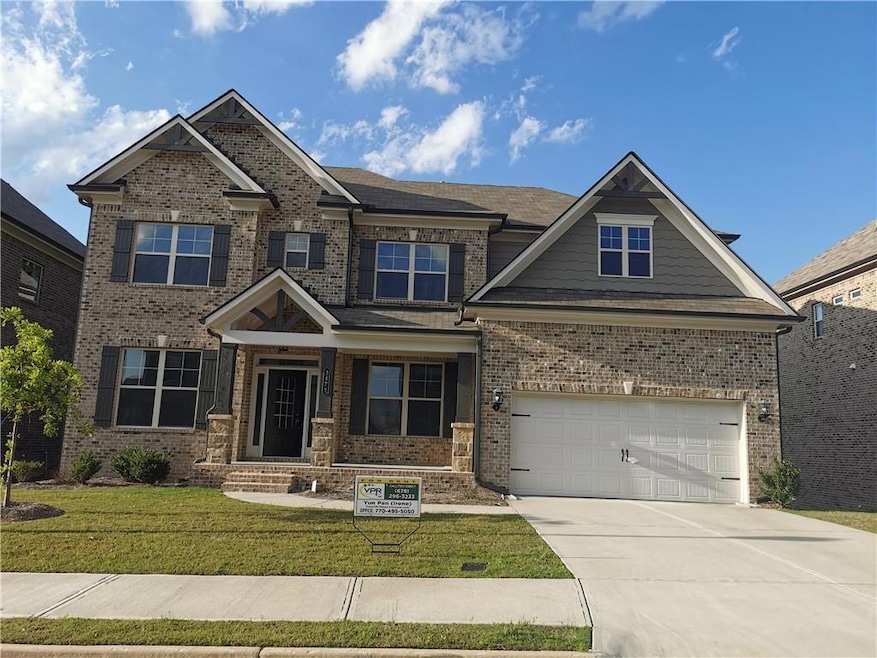 Craftsman house featuring a porch, driveway, brick siding, a front yard, and a garage