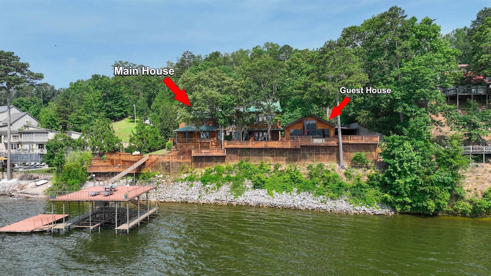 Dock featuring boat lift and a deck with water view