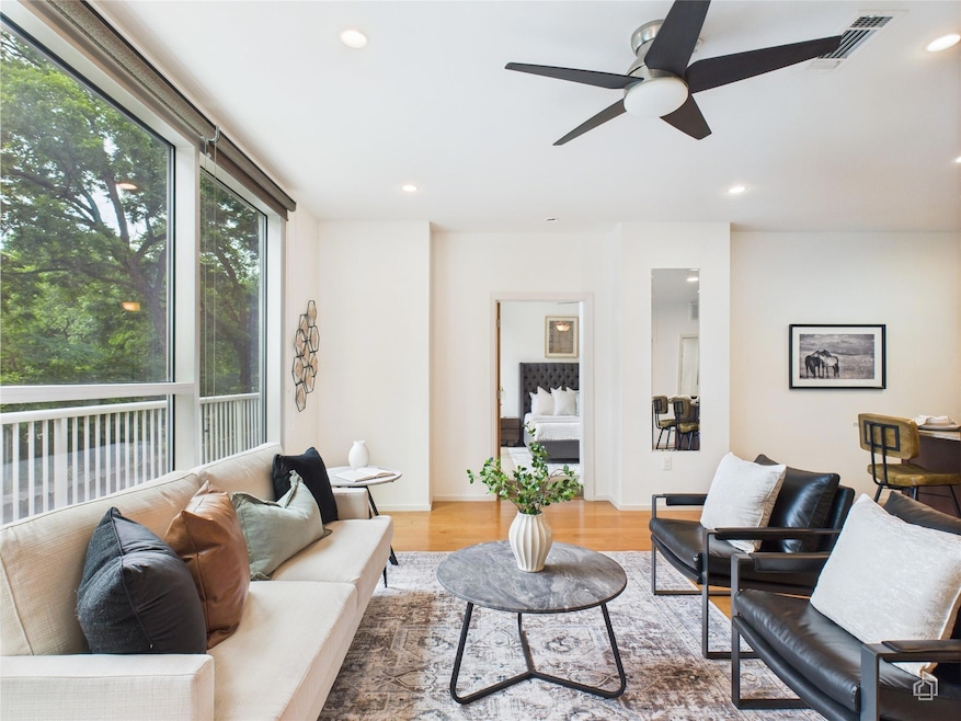Living room with light wood-style flooring, reces