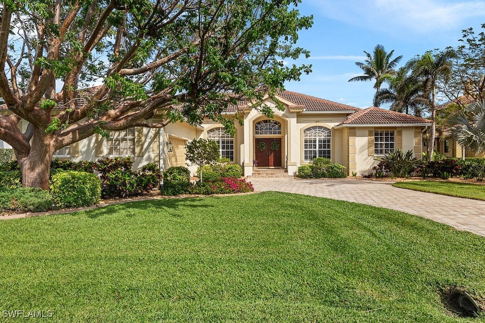 Mediterranean / spanish house featuring a front yard, driveway, a tiled roof, and stucco siding