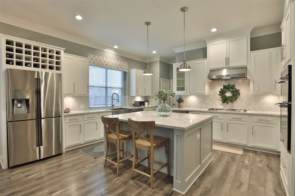STUNNING completely renovated kitchen which includes custom on-site built shaker style cabinetry and drawers, expanded island with custom trim work, built-in wine rack above kitchen refrigerator and MORE!
