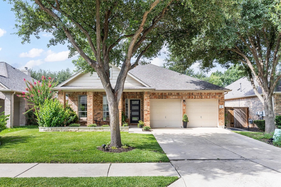Single story home featuring brick siding, drivewa