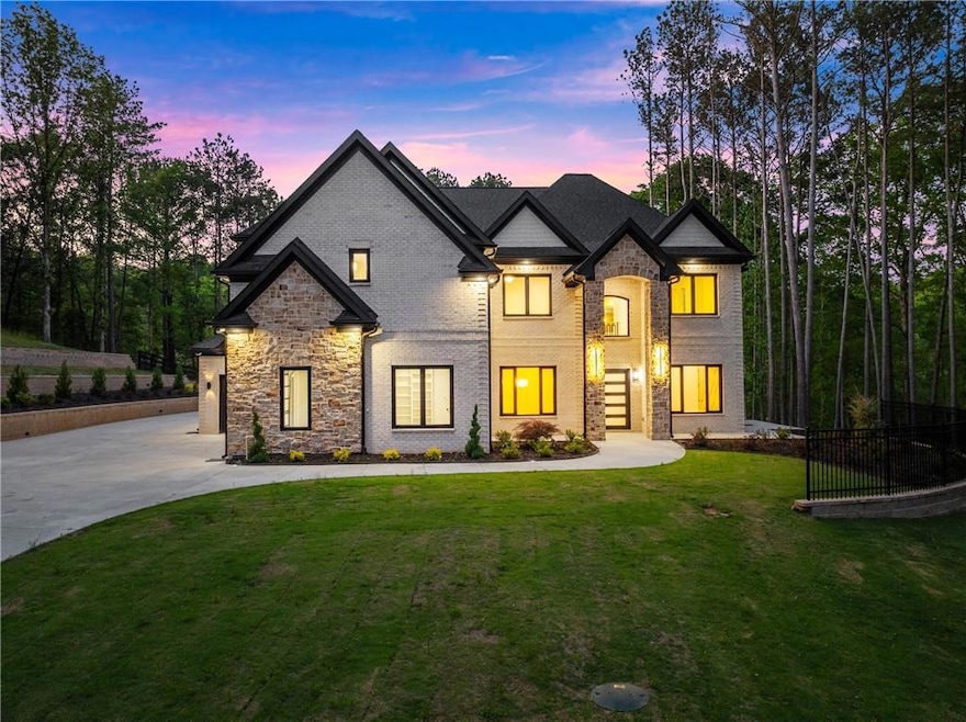French provincial home featuring a lawn, stone siding, and concrete driveway