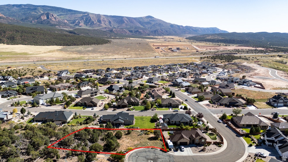 Aerial perspective of suburban area with a mountain backdrop and property boundaries highlighted