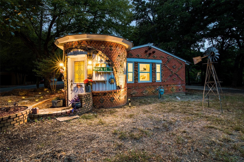 The Hobbit House shines at night beneath the oak t
