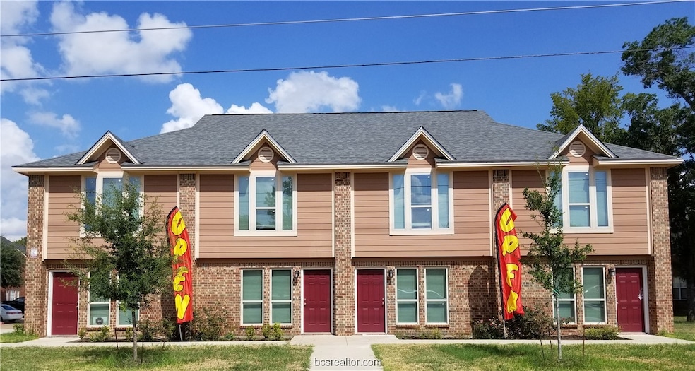 Bi-level home featuring brick siding, a front yard, and a shingled roof
