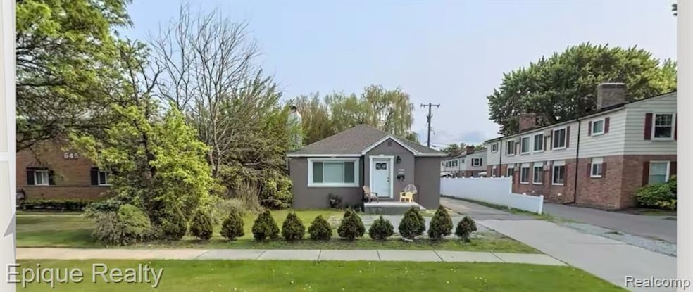 View of front facade featuring a front yard and stucco siding