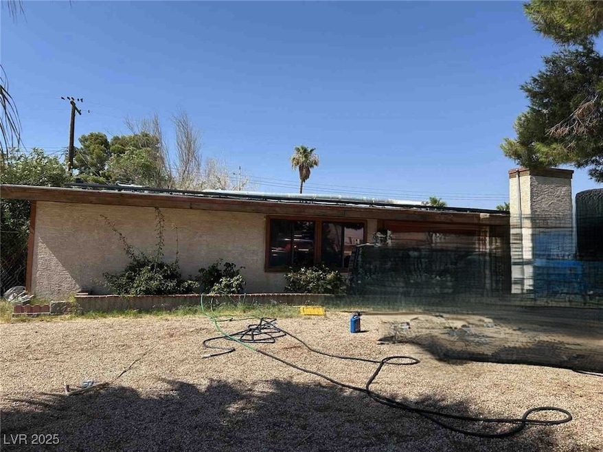 Rear view of property with stucco siding and a chi