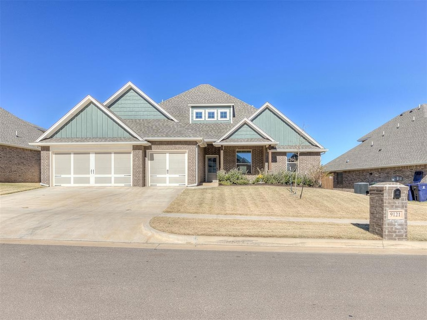 Craftsman-style house with roof with shingles, driveway, a garage, board and batten siding, and brick siding