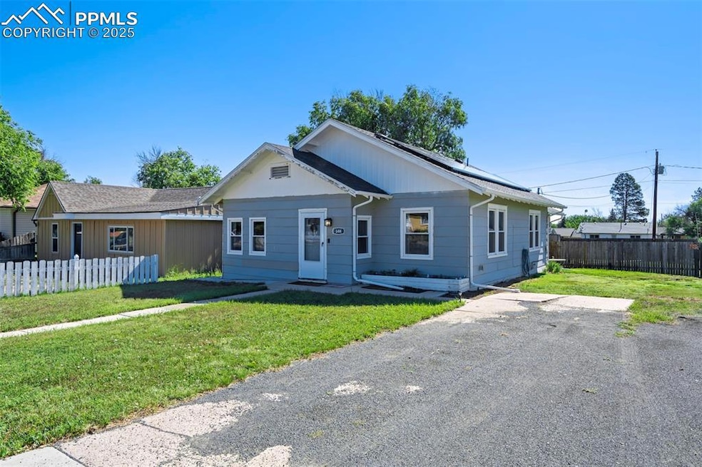 View of front of house with roof mounted solar panels and a fenced backyard
